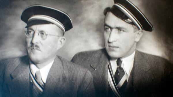 Schwarz-weiß-Bild von zwei Männern mit Mützen. Es ist Wilhelm Seyd und sein Sohn Albert, zwei Inhaber-Generationen der Mohren-Apotheke.
